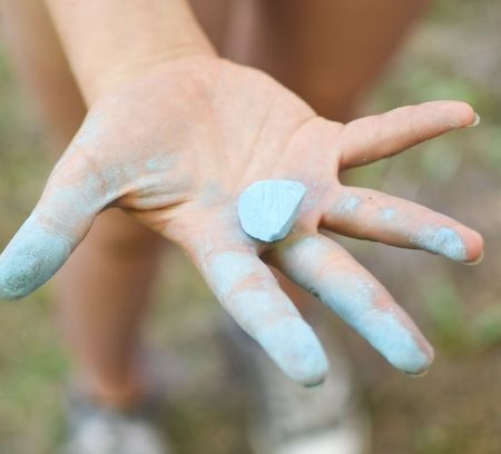 kids hand holding blue chalk