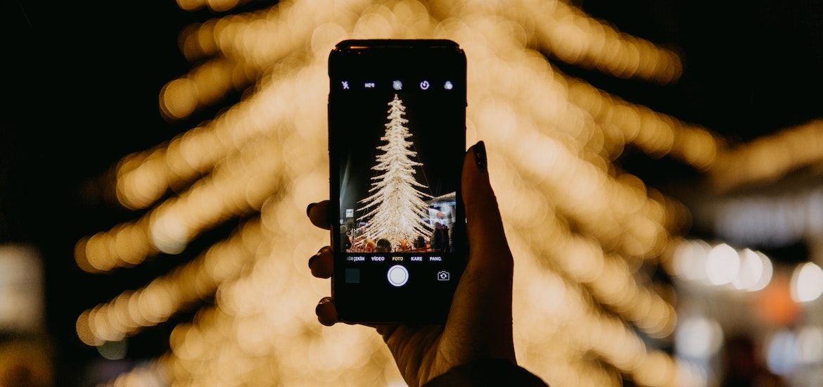 a woman takes a photo of a xmas tree