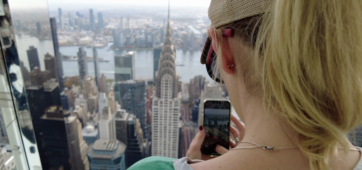A lady takes a photo of the Chrysler building from Summit One